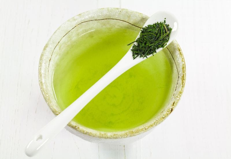 Tazza di tè Gyokuro con un cucchiaio con foglie